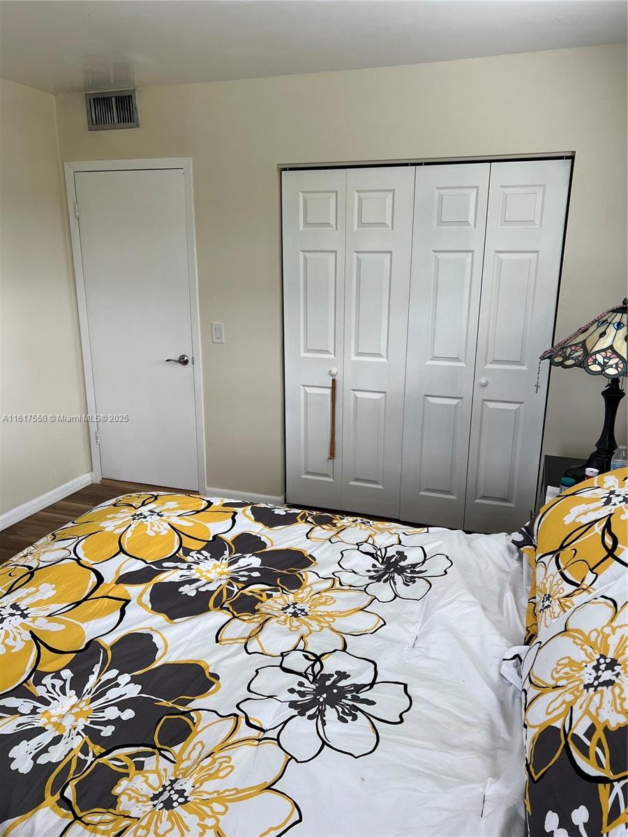 155 Suffolk F, Unit D Boca Raton, FL 33434 - Photo 18 of 41 a bedroom with a bed and a dresser