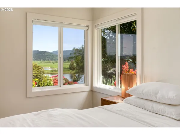 a bedroom with a large window and a bed