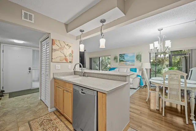 a kitchen with stainless steel appliances a sink a stove a table and chairs