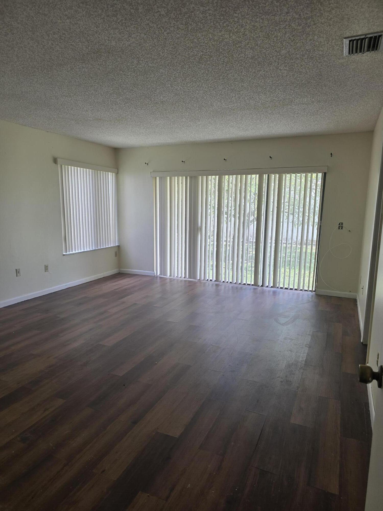 12730 Southwest 112th Street Miami, FL 33186 - Photo 11 of 11 an empty room with wooden floor and windows