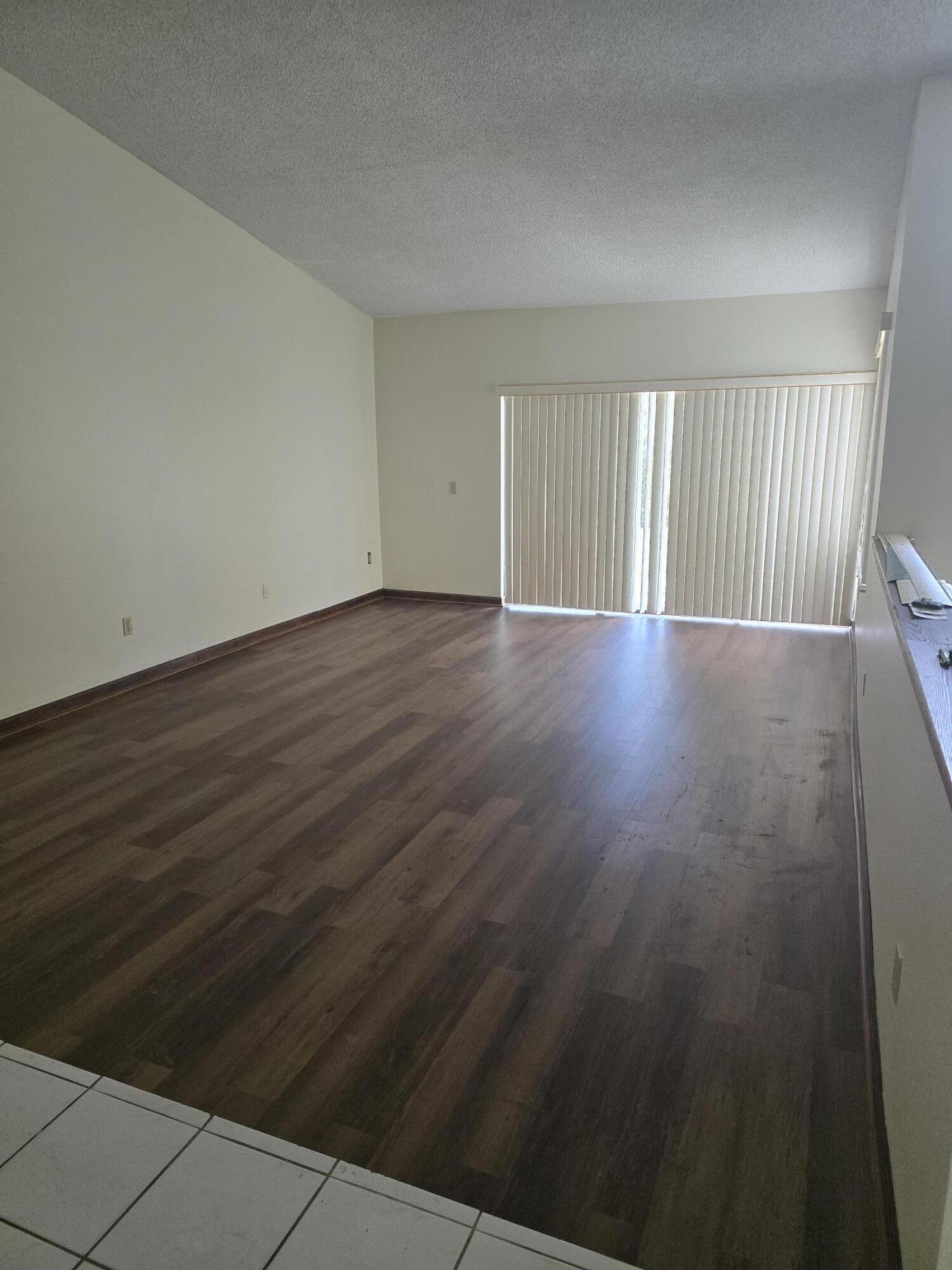 12730 Southwest 112th Street Miami, FL 33186 - Photo 8 of 11 a view of an empty room with wooden floor and a window
