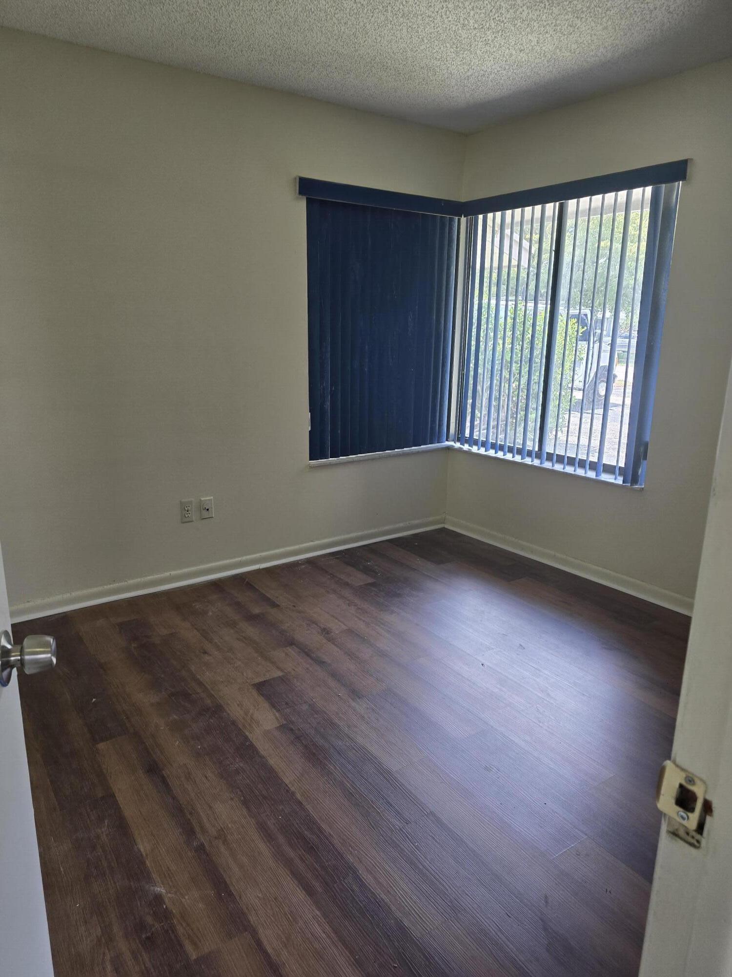12730 Southwest 112th Street Miami, FL 33186 - Photo 9 of 11 an empty room with wooden floor and windows