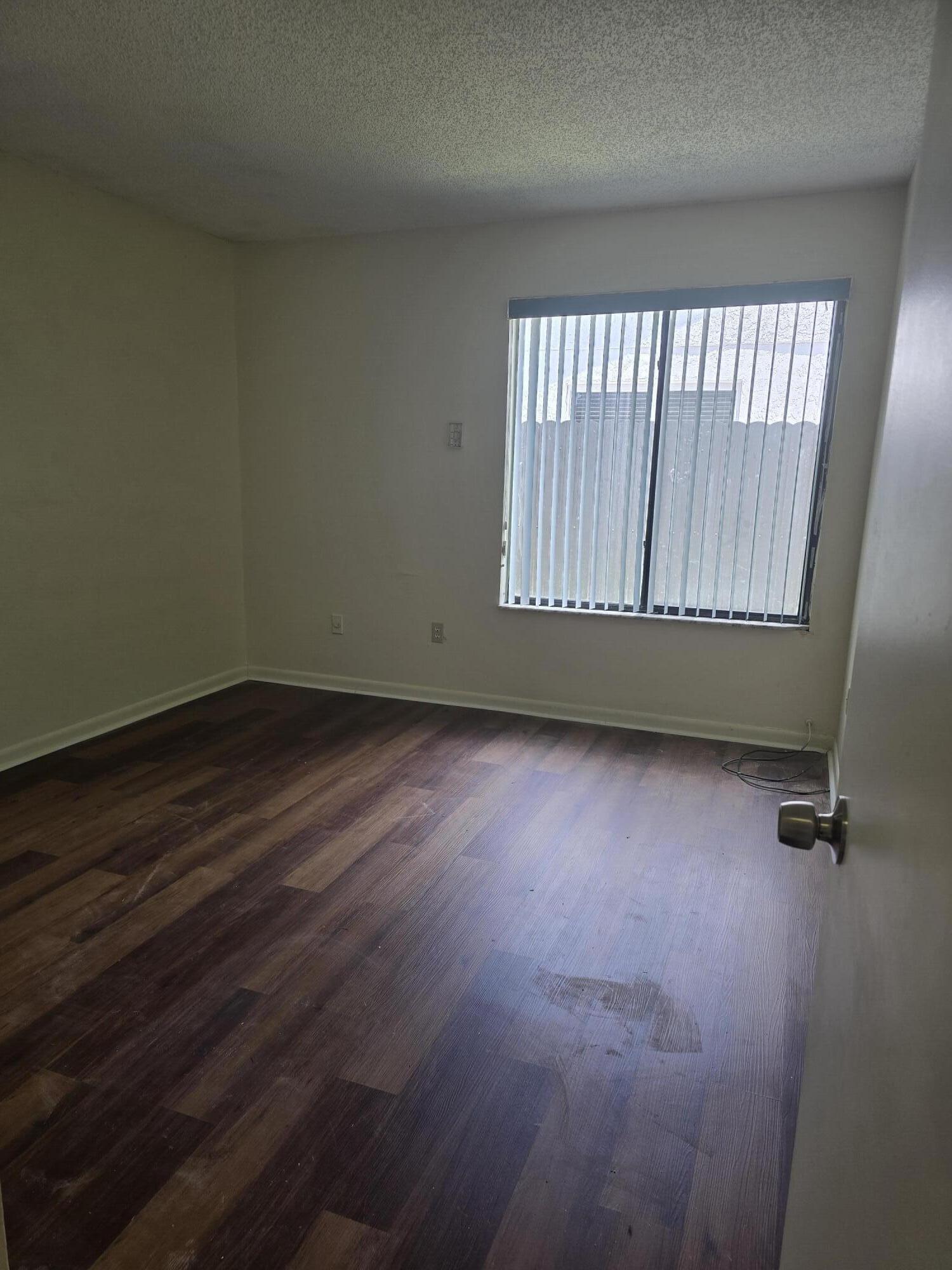12730 Southwest 112th Street Miami, FL 33186 - Photo 10 of 11 an empty room with wooden floor and windows