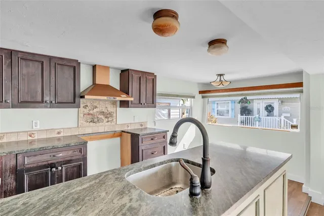 a kitchen with stainless steel appliances granite countertop a sink and dishwasher a stove top oven with wooden floor
