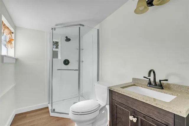 a bathroom with a granite countertop sink toilet and shower