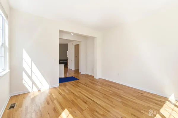 a view of a big room with wooden floor and a bathroom