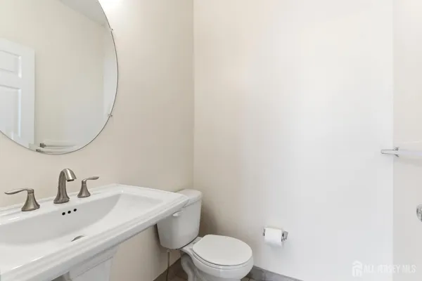 a bathroom with a toilet a sink and mirror