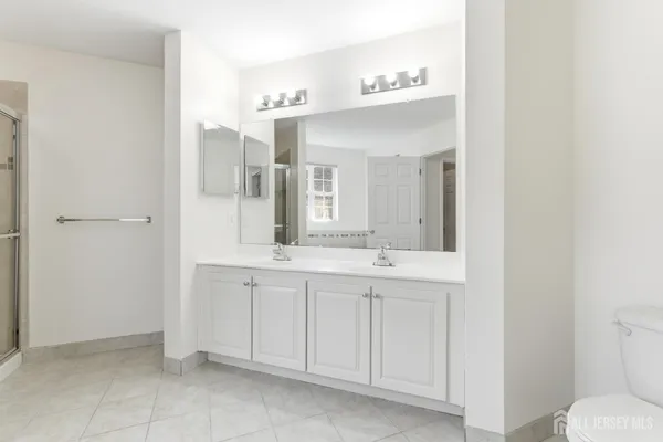 a spacious bathroom with a double vanity sink and a mirror