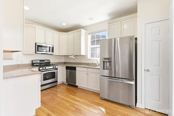 a kitchen with granite countertop a refrigerator stove and microwave