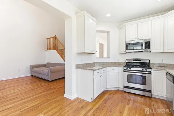 a kitchen with granite countertop a stove a sink and a microwave