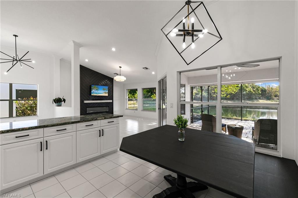 7867 Gardner Drive Naples, FL 34109 - Photo 14 of 36 Dining space featuring hanging lights, vaulted ceiling, and light tile patterned floors