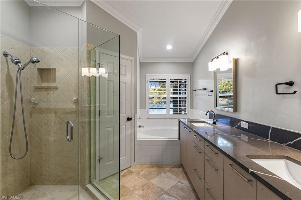 7867 Gardner Drive Naples, FL 34109 - Photo 16 of 36 Full bathroom featuring a shower stall, a bath, double vanity, and ornamental molding