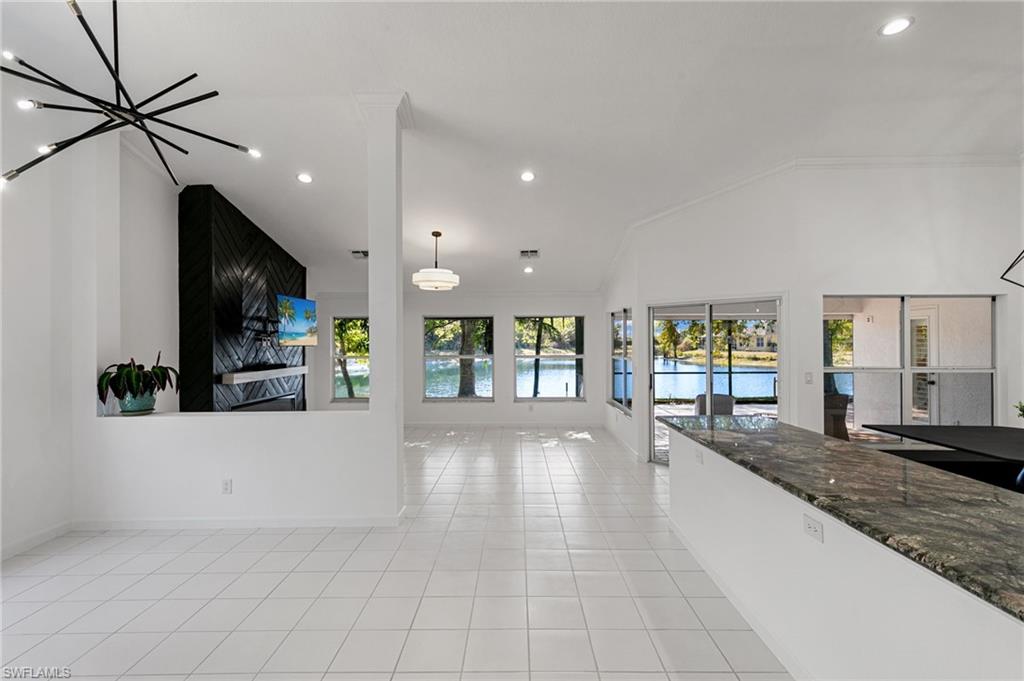 7867 Gardner Drive Naples, FL 34109 - Photo 2 of 36 Unfurnished living room with recessed lighting, light tile patterned flooring, and lofted ceiling