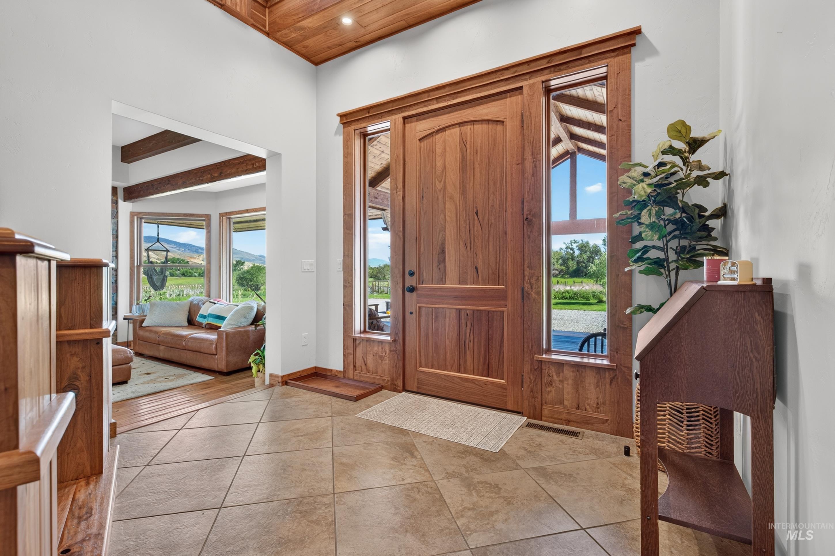 63 Mountain View Road Salmon, ID 83467 - Photo 10 of 50 Entryway featuring a solid wood door with sidelight windows, tile flooring, and a wood-paneled ceiling