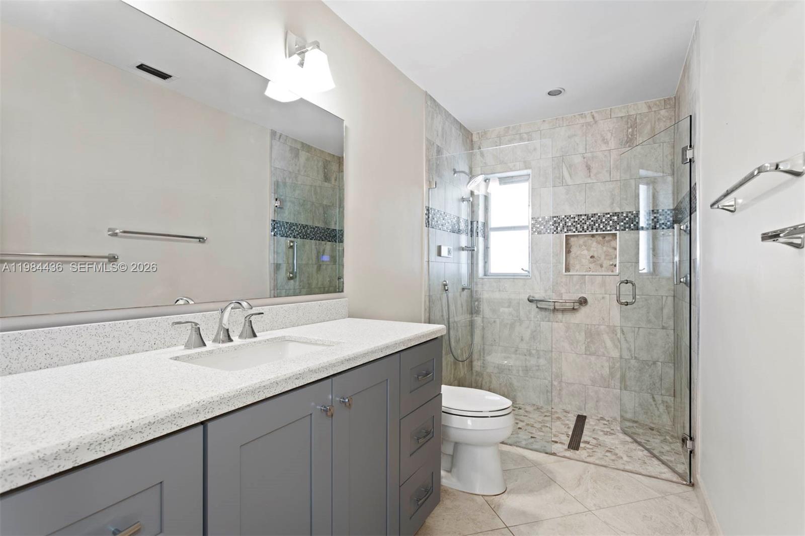 11807 Southwest 112th Avenue Miami, FL 33176 - Photo 13 of 48 a bathroom with a granite countertop sink a toilet a mirror and shower