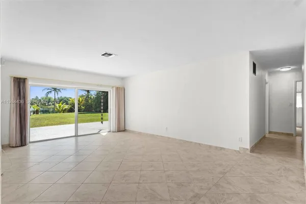 a view of an empty room with a floor to ceiling window and garden view