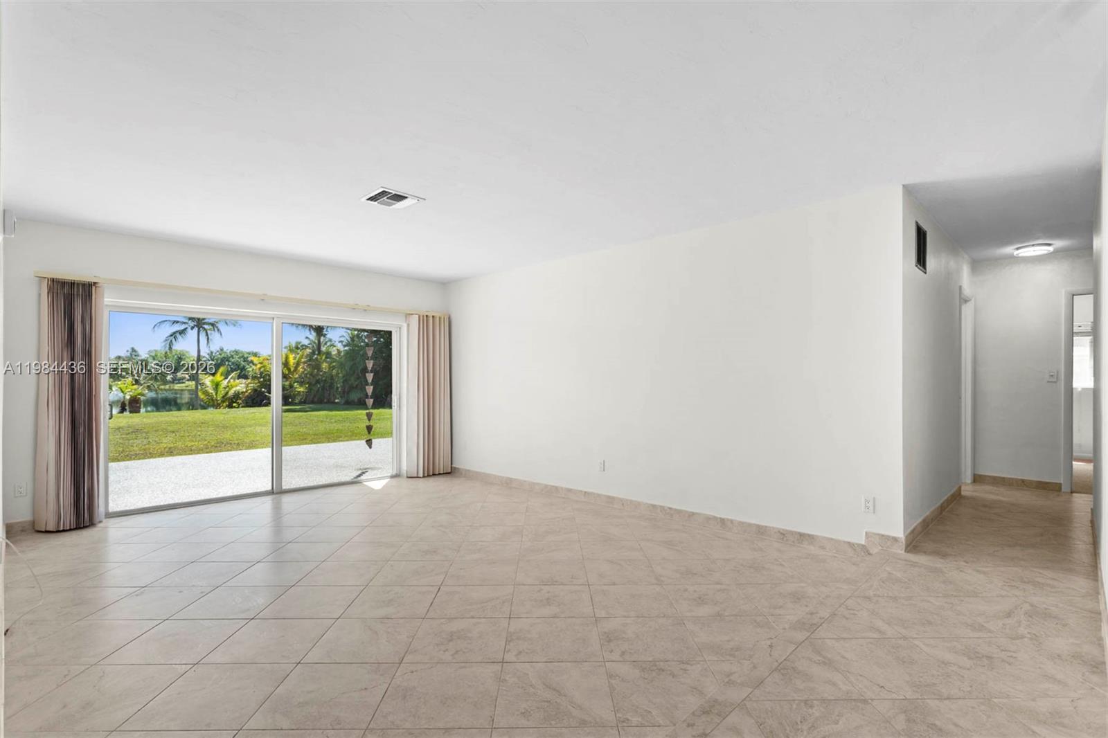 11807 Southwest 112th Avenue Miami, FL 33176 - Photo 17 of 48 a view of an empty room with a floor to ceiling window and garden view
