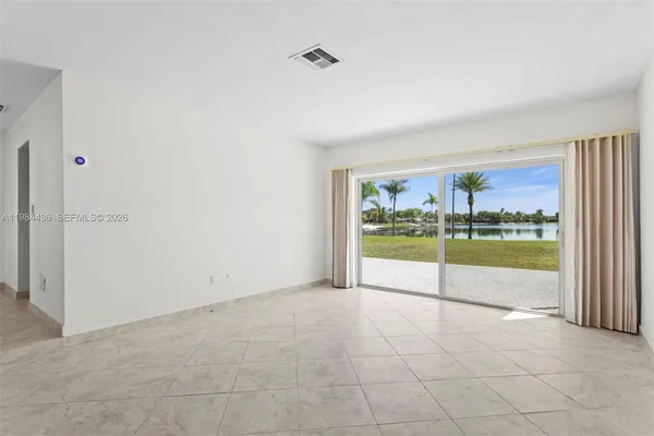 an empty room with floor to ceiling window and an outdoor view
