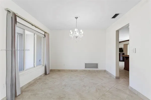 a view of a chandelier in big room and a bathroom