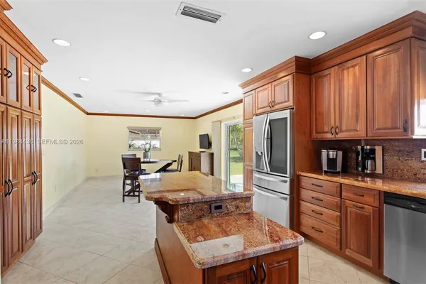 a kitchen with stainless steel appliances granite countertop a stove refrigerator and cabinets
