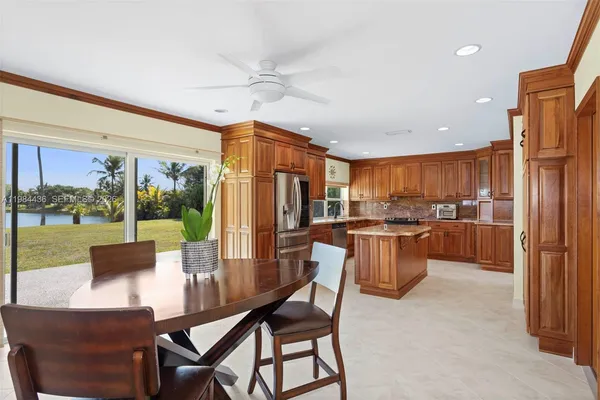 a dining room with furniture a large window and a kitchen view