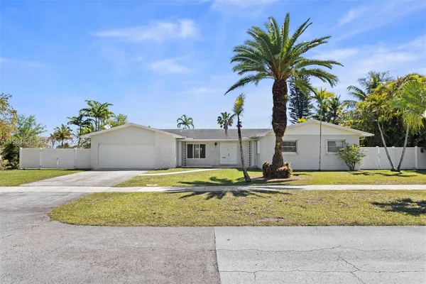 a house with a yard and palm trees