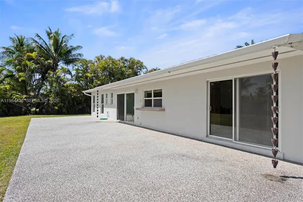 front view of a house with a yard and potted plants