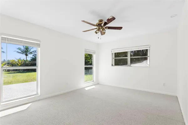 a view of a livingroom with a ceiling fan and window
