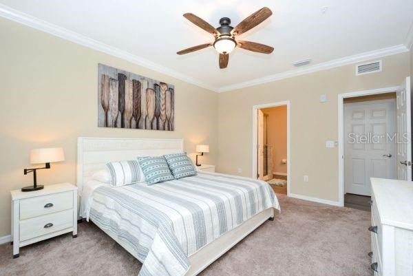 4212 Expedition Way Osprey, FL 34229 - Photo 14 of 28 a bedroom with a large bed and a chandelier