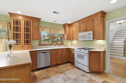 a kitchen with stainless steel appliances granite countertop a stove a sink dishwasher and a refrigerator