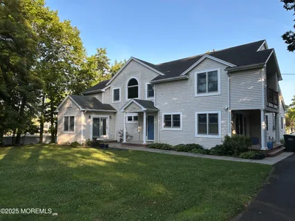 a front view of a house with a garden and trees