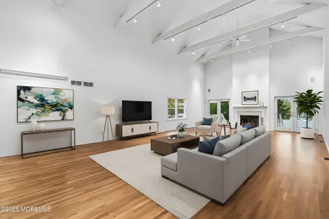 a living room with furniture a fireplace a flat screen tv and a potted plant