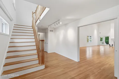 a view of a hallway view with wooden floor and staircase