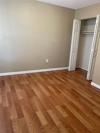 an empty room with wooden floor and a window