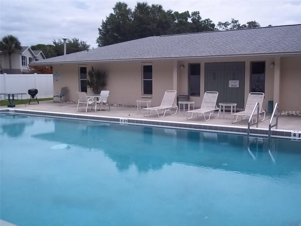 4800 Rilma Avenue, Unit 146 Sarasota, FL 34234 - Photo 14 of 15 a view of a patio with swimming pool table and chairs