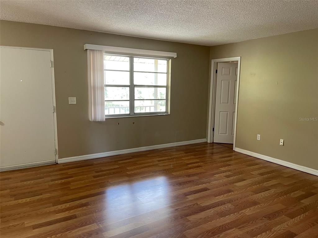 4800 Rilma Avenue, Unit 146 Sarasota, FL 34234 - Photo 3 of 15 an empty room with wooden floor and windows