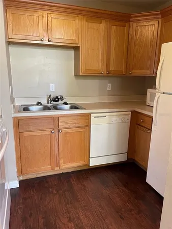 a kitchen with granite countertop cabinets stainless steel appliances a sink and wooden floor
