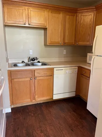 a kitchen with granite countertop cabinets stainless steel appliances a sink and wooden floor