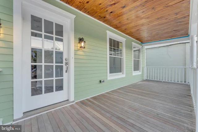 a view of empty room with wooden floor and windows