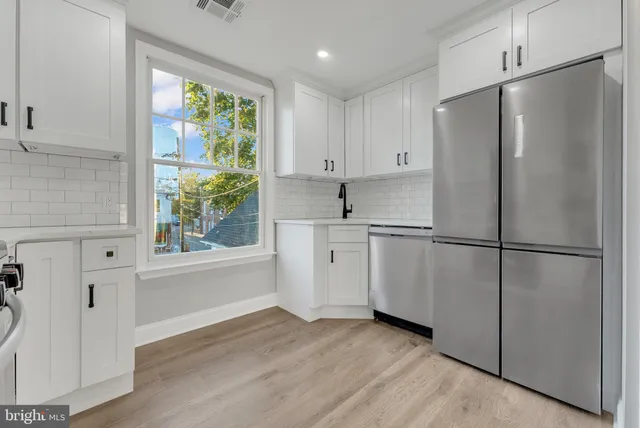 a kitchen with white cabinets and white appliances