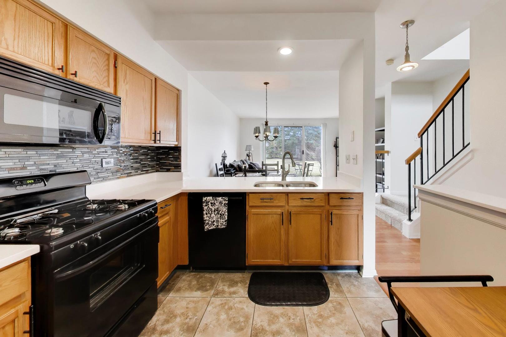 17804 Braewick Road Gurnee, IL 60031 - Photo 12 of 27 a kitchen with stainless steel appliances kitchen island granite countertop a stove a sink and a microwave