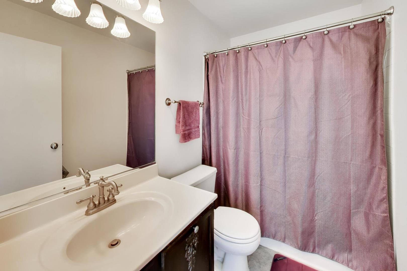 17804 Braewick Road Gurnee, IL 60031 - Photo 18 of 27 a bathroom with a sink a toilet and shower curtain