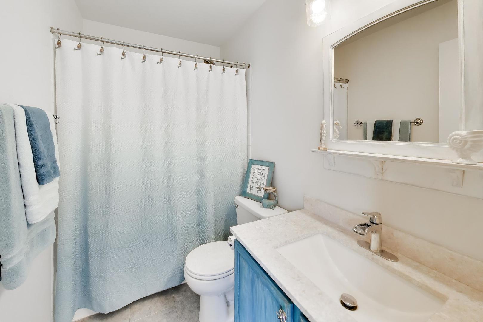 17804 Braewick Road Gurnee, IL 60031 - Photo 21 of 27 a bathroom with a sink a toilet and shower curtain