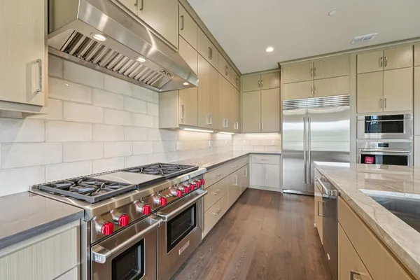 a kitchen with stainless steel appliances a sink dishwasher stove and refrigerator