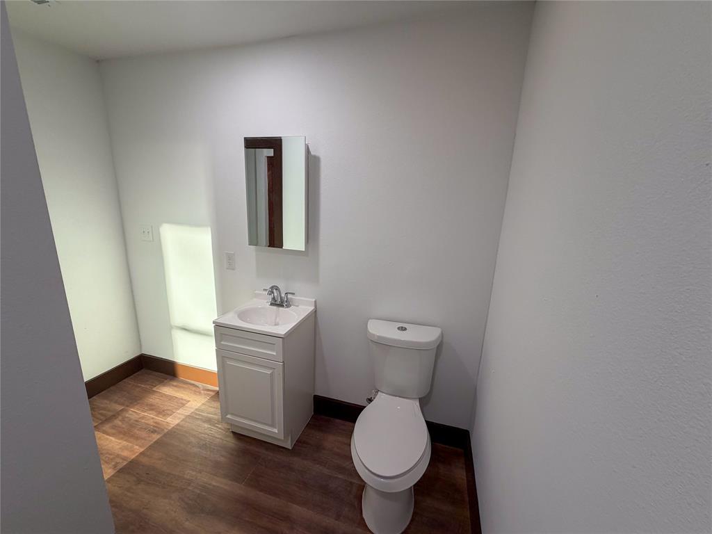 107 East Stone Street, Unit B Collinsville, TX 76233 - Photo 13 of 16 a bathroom with a toilet a sink and mirror