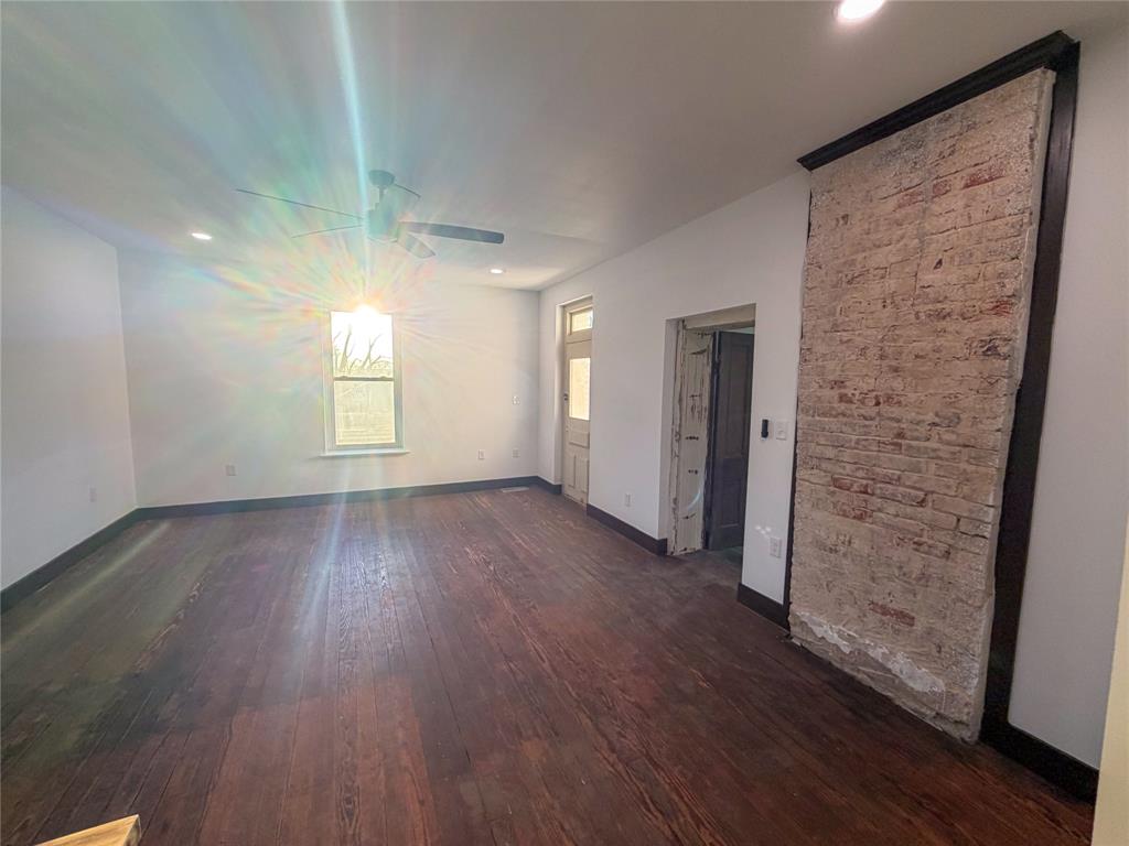 107 East Stone Street, Unit B Collinsville, TX 76233 - Photo 3 of 16 wooden floor in an empty room with a window