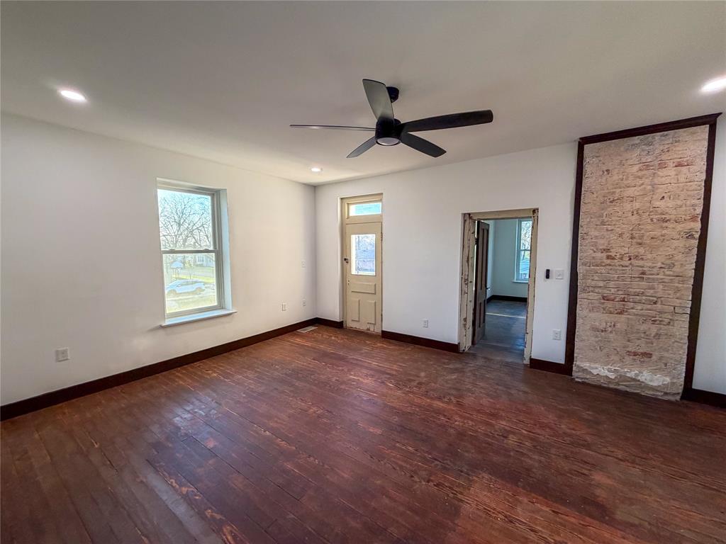 107 East Stone Street, Unit B Collinsville, TX 76233 - Photo 4 of 16 a view of empty room with wooden floor and window