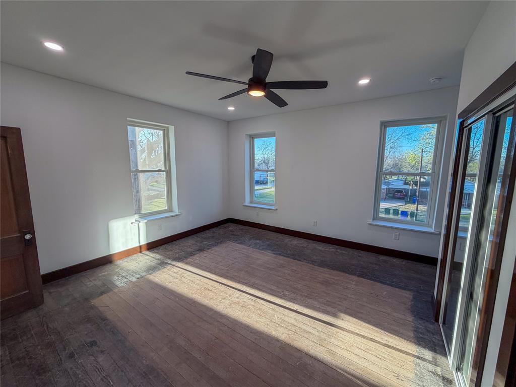 107 East Stone Street, Unit B Collinsville, TX 76233 - Photo 6 of 16 wooden floor in an empty room with a window