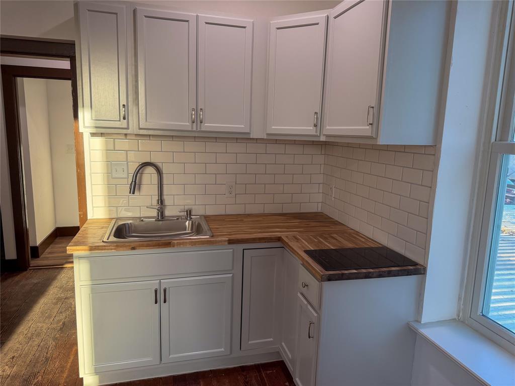 107 East Stone Street, Unit B Collinsville, TX 76233 - Photo 9 of 16 a kitchen with white cabinets and sink