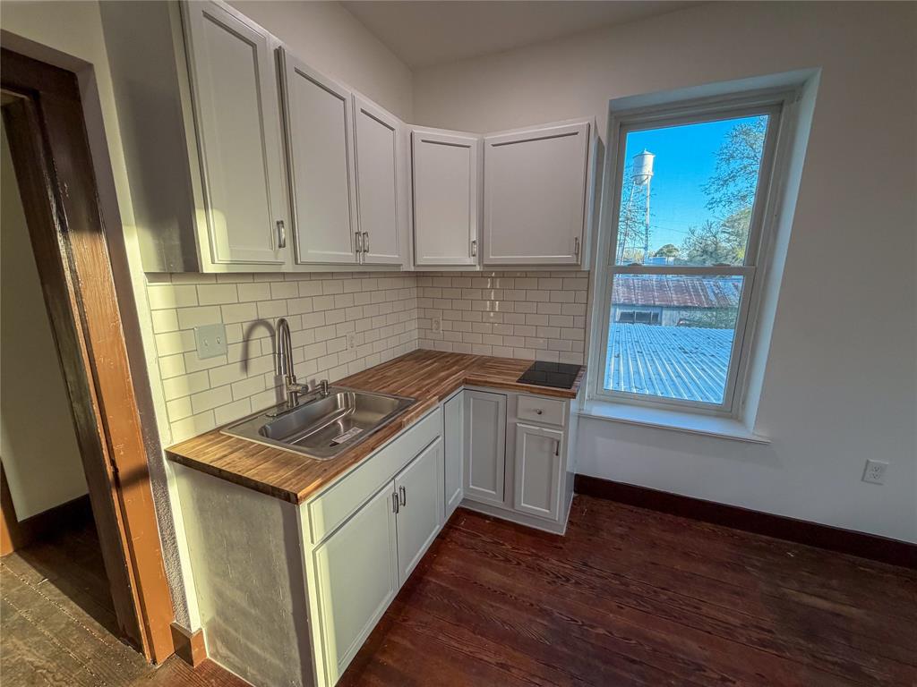 107 East Stone Street, Unit B Collinsville, TX 76233 - Photo 10 of 16 a kitchen with sink cabinets and wooden floor